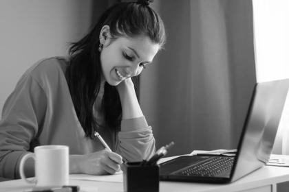 Beautiful girl using laptop studying at home, online education concept, studying science behind a laptop. Watching a webinar, looking for friends on social networks. Modern technologies