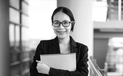 Young Asian business woman wear suit holding file document, standing at office