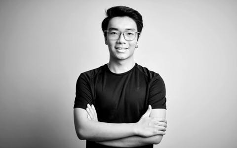 Young Singaporean male professional with arms crossed, symbolizing the readiness to embrace challenges in the tech and design industry.