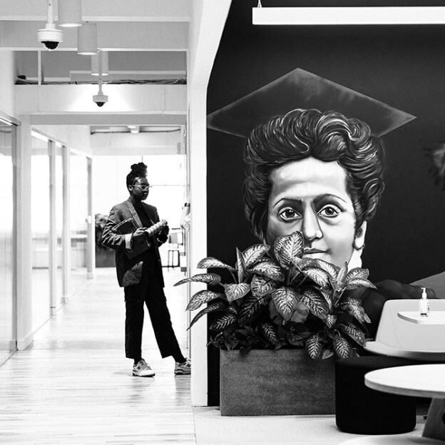 Student standing next to wall art in GA NYC campus