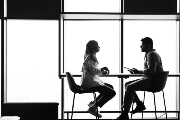 A man and a women sitting at a tall table discussing the benefits of reskilling